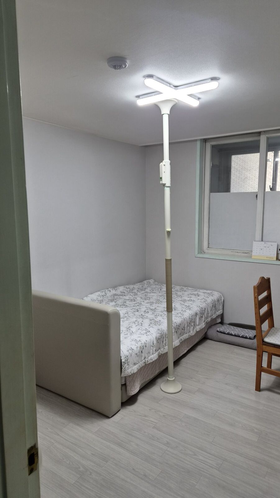 광주남구 재가복지와 함께 안내하는 복지용구 참고사진 - 침대 옆 바닥과 천장 사이에 고정한 기둥형 안전손잡이